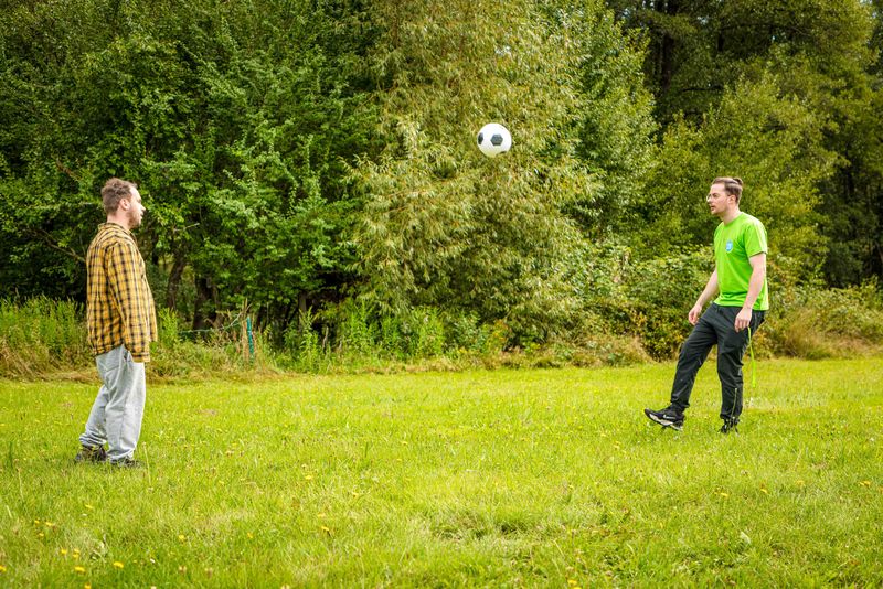 Bewegung und Spaß im Freien – Fußball im Grünthaler Hof Parkstein, Dr. Loew Einrichtung Klient:innen des Grünthaler Hofs Parkstein spielen Fussball auf der Wiese vor der Einrichtung