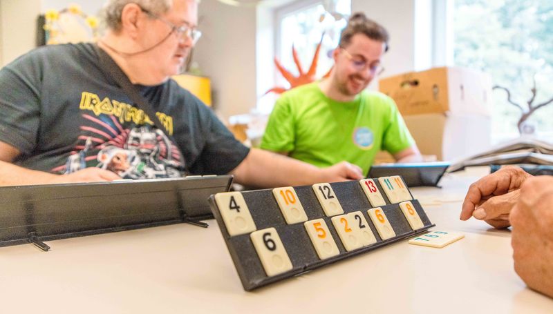 Gemeinschaft und Spiel im Grünthaler Hof Parkstein – Dr. Loew Einrichtung für Menschen mit psychischen Erkrankungen Klient:innen des Grünthaler Hofs Parkstein spielen gemeinsam ein Gesellschaftsspiel im Aufenthaltsraum