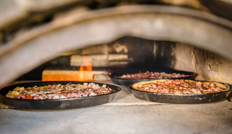 Pizza im Holzofen backen – Gemeinschaftsaktivität im Grünthaler Hof Parkstein, Dr. Loew Einrichtung Frische Pizzen backen im Holzofen des Grünthaler Hofs Parkstein während einer Gemeinschaftsaktion
