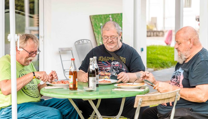 Gemeinsame Mahlzeit im Freien – Grünthaler Hof Parkstein, Dr. Loew Einrichtung Klient:innen des Grünthaler Hofs Parkstein essen gemeinsam im Außenbereich und genießen die Gemeinschaft