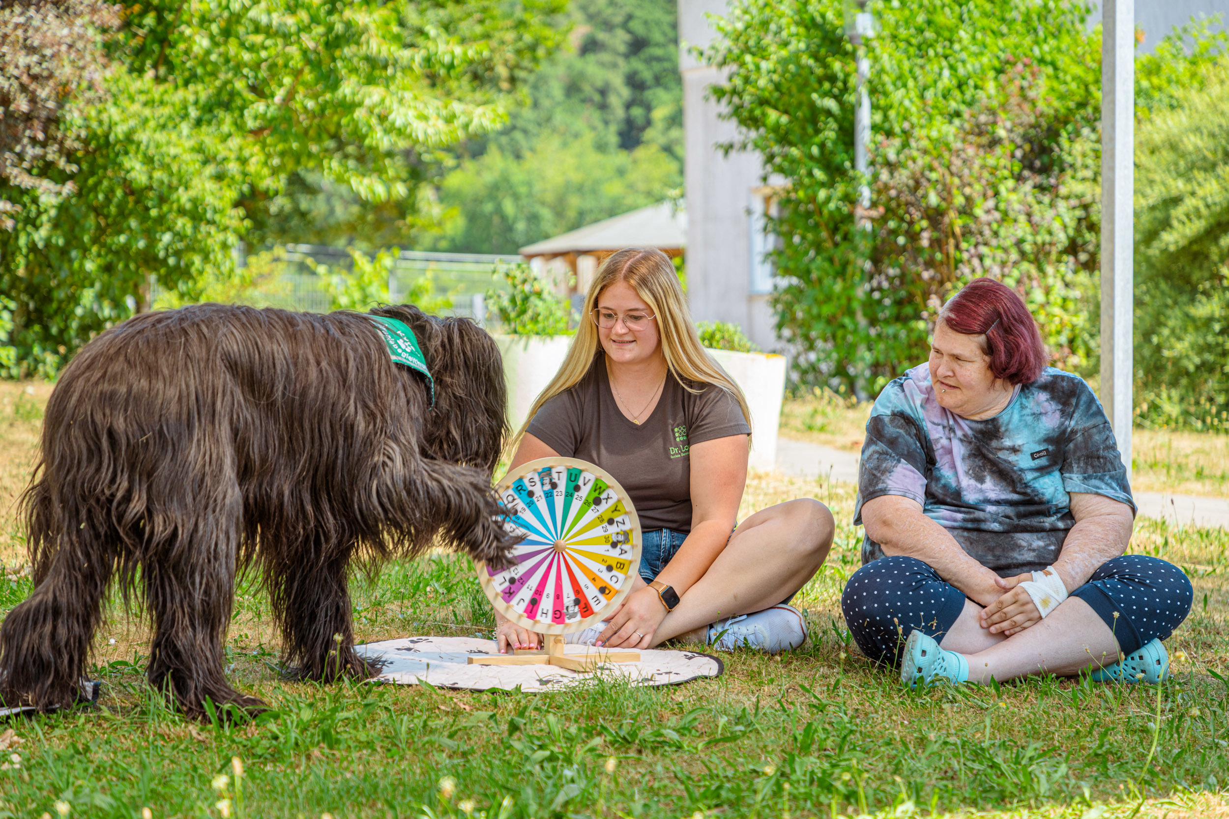 Hundetherapie im Freien mit Mitarbeiterin und Klientin der Dr. Loew Einrichtung für Menschen mit psychischen Erkrankungen
