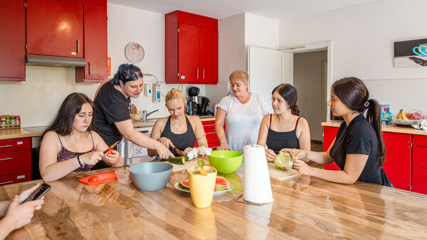 Gemeinsames Kochen mit mehreren Personen in der Küche der Dr. Loew Einrichtung Jugendbetreuung