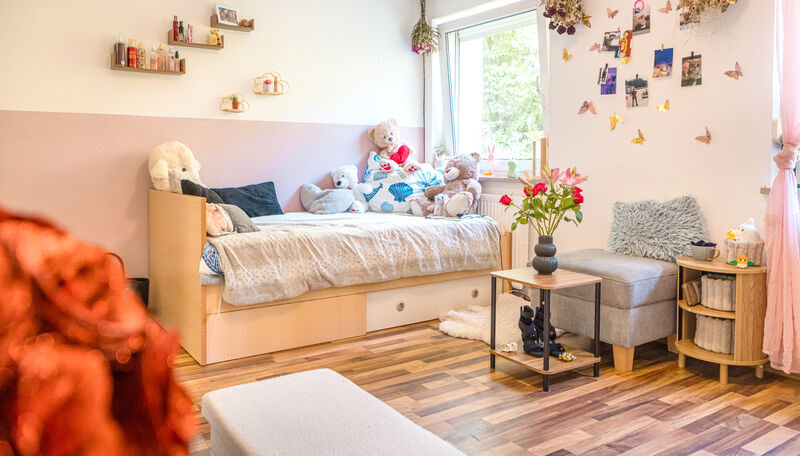 Eingerichtetes Jugendzimmer mit Bett, Sitzmöbeln und persönlichen Dekorationen in der Jugendwohngruppe Laura