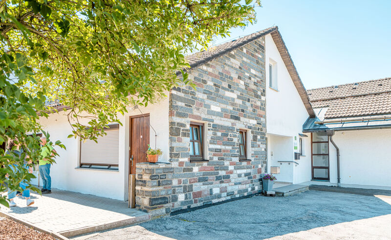 Eingangsbereich des Hauses Zwiesel der Dr. Loew Einrichtung Rabenstein mit Natursteinfassade