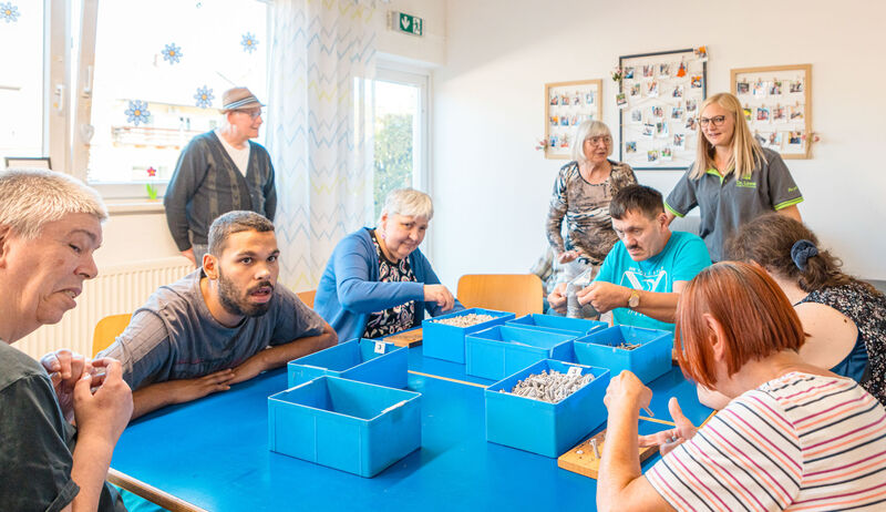 Klient:innen und Mitarbeitende bei einer gemeinsamen Beschäftigung im tagesstrukturierenden Angebot von Dr. Loew Rabenstein