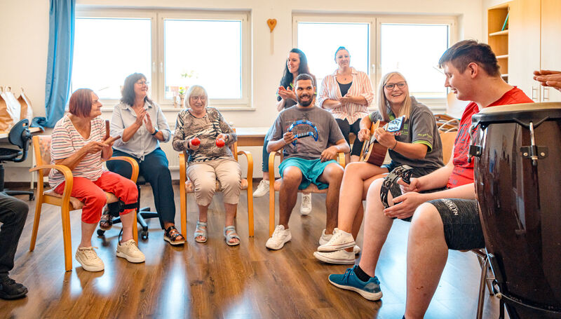 Klient:innen und Mitarbeitende beim gemeinsamen Musizieren im tagesstrukturierenden Angebot von Dr. Loew Rabenstein